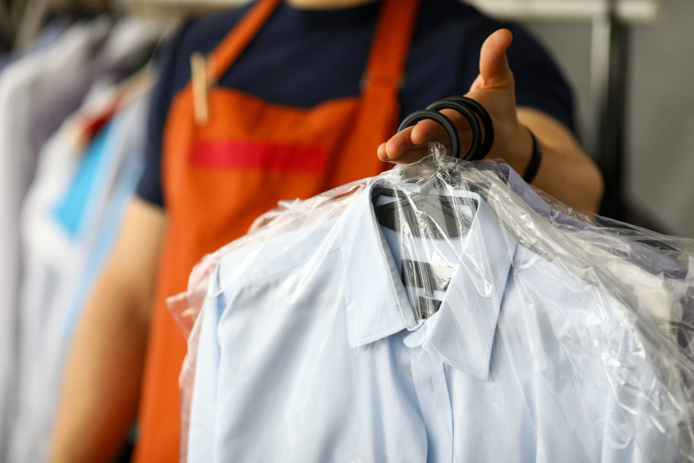 Clothes,Dry,Cleaning,Service,Worker,Returning,Shirts,To,Customer,Close-up