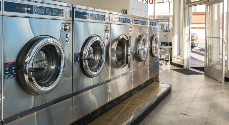 Modern washers and dryers inside a clean and well-lit laundromat