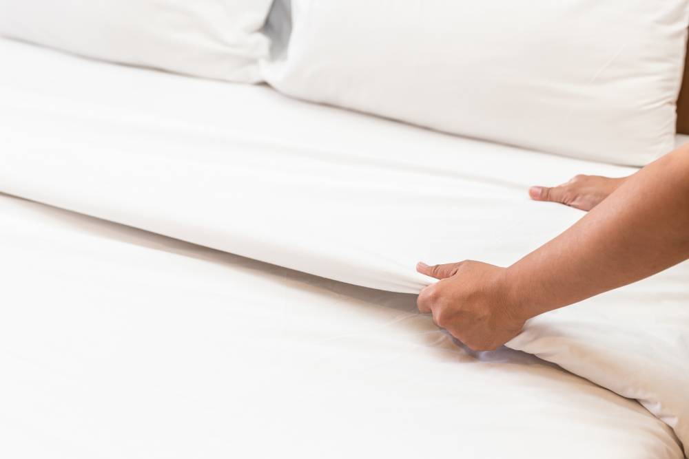 Crisp, clean white bed sheet folded neatly