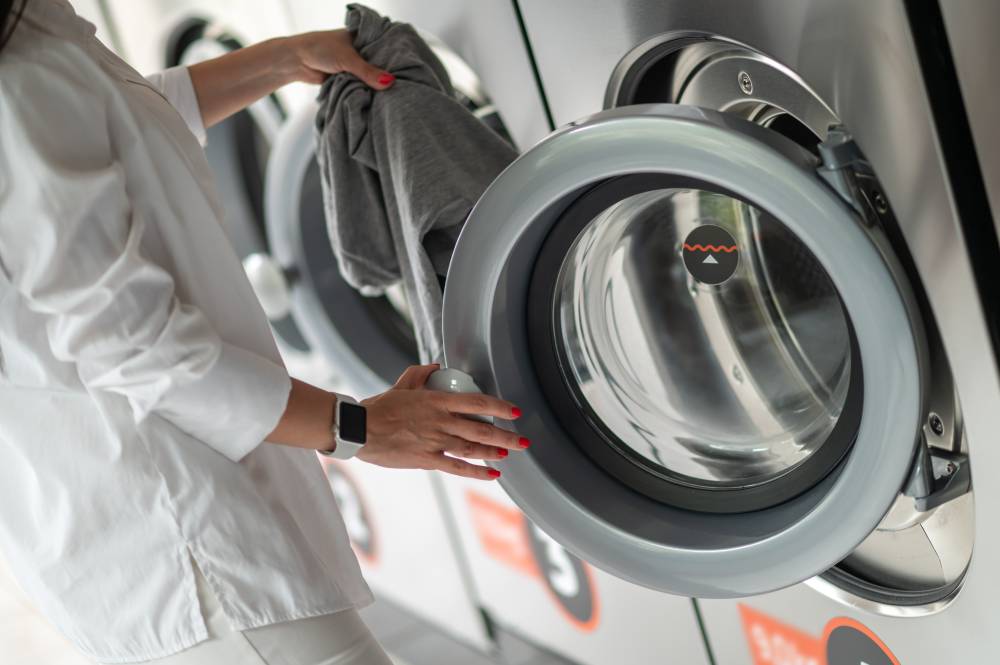 Customer loading laundry into a modern self-service washer