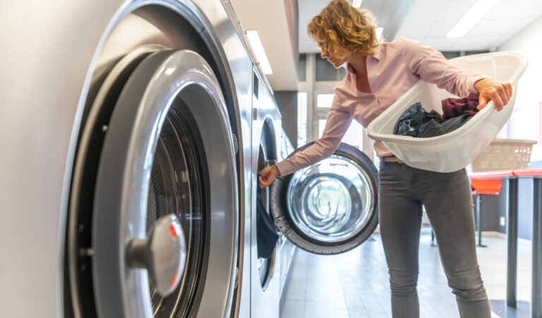 Customer loading clothes into washer at Midland commercial laundry