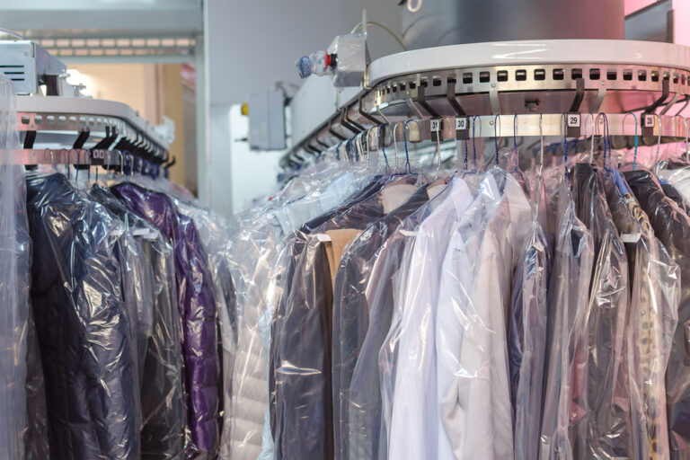 Clean clothes hanging on racks at full-service laundromat in Odessa