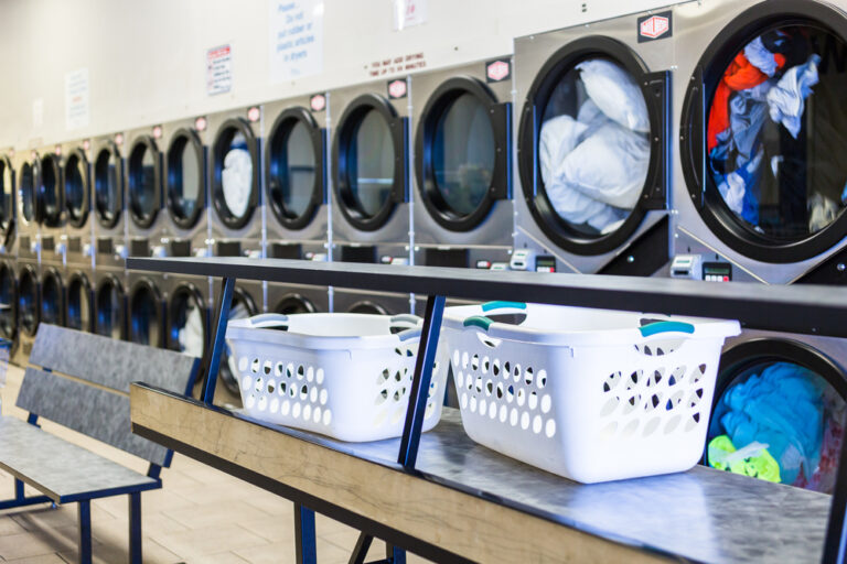 Folding area with baskets and commercial washers at Wash Em Up